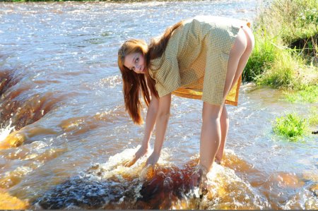  Рыжая красавица эротично позирует у реки