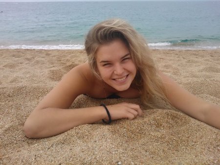 Молодая подруга загорает на пляже с голыми сиськами