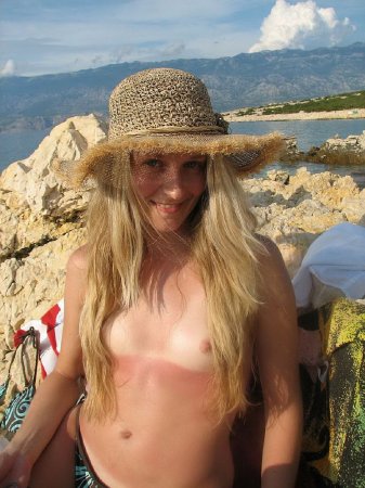 Молодая подруга загорает на пляже с голыми сиськами